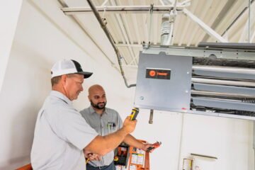 Senior technician supervising a beginner in hvac apprentice jobs training.