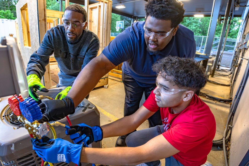 Senior hvac technician mentoring an apprentice on a job site
